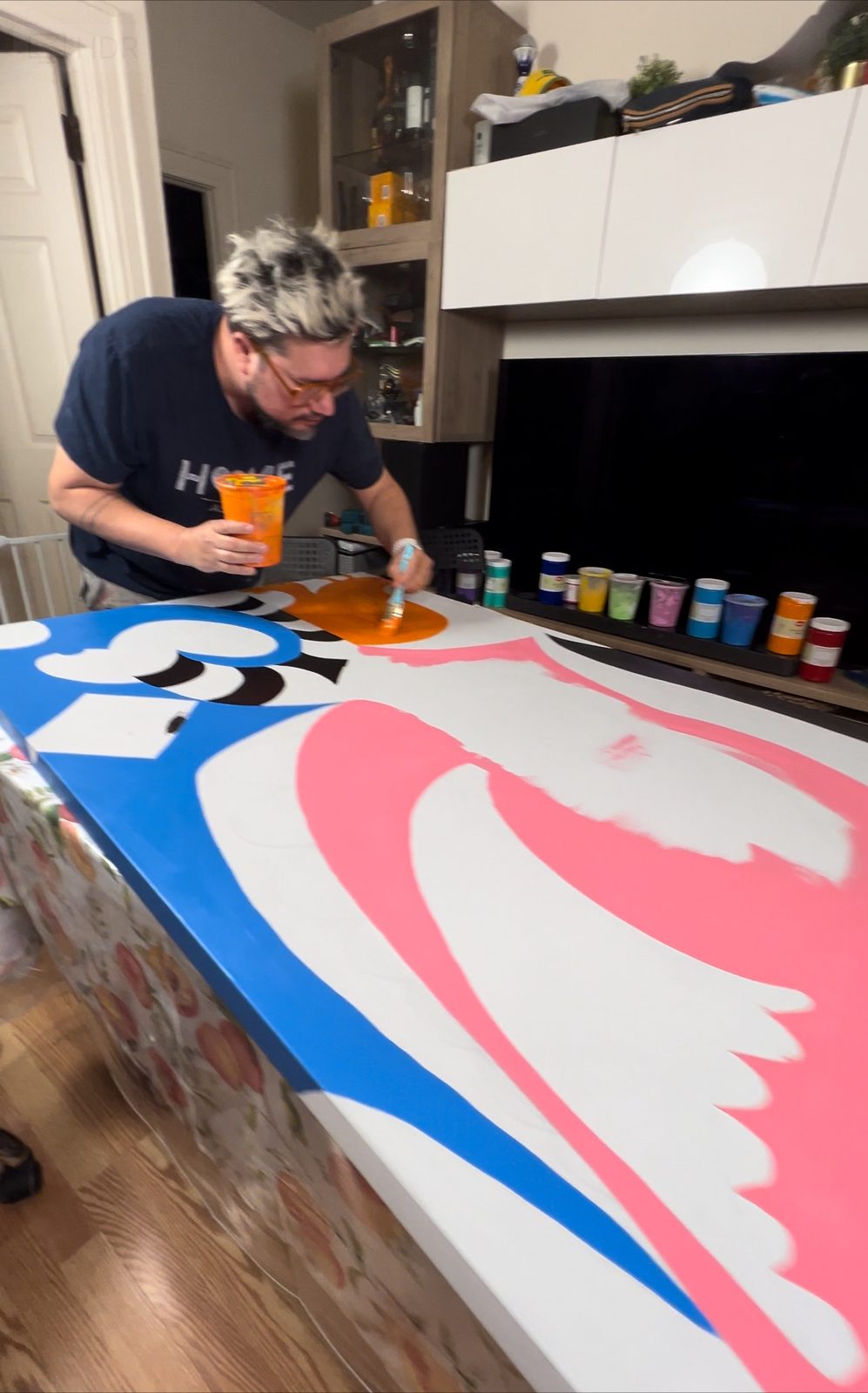Tony painting a large canvas on the floor