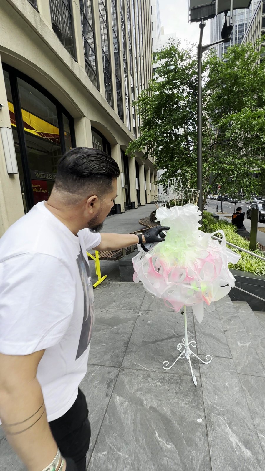 Tony spray-painting a gown on the sidewalk