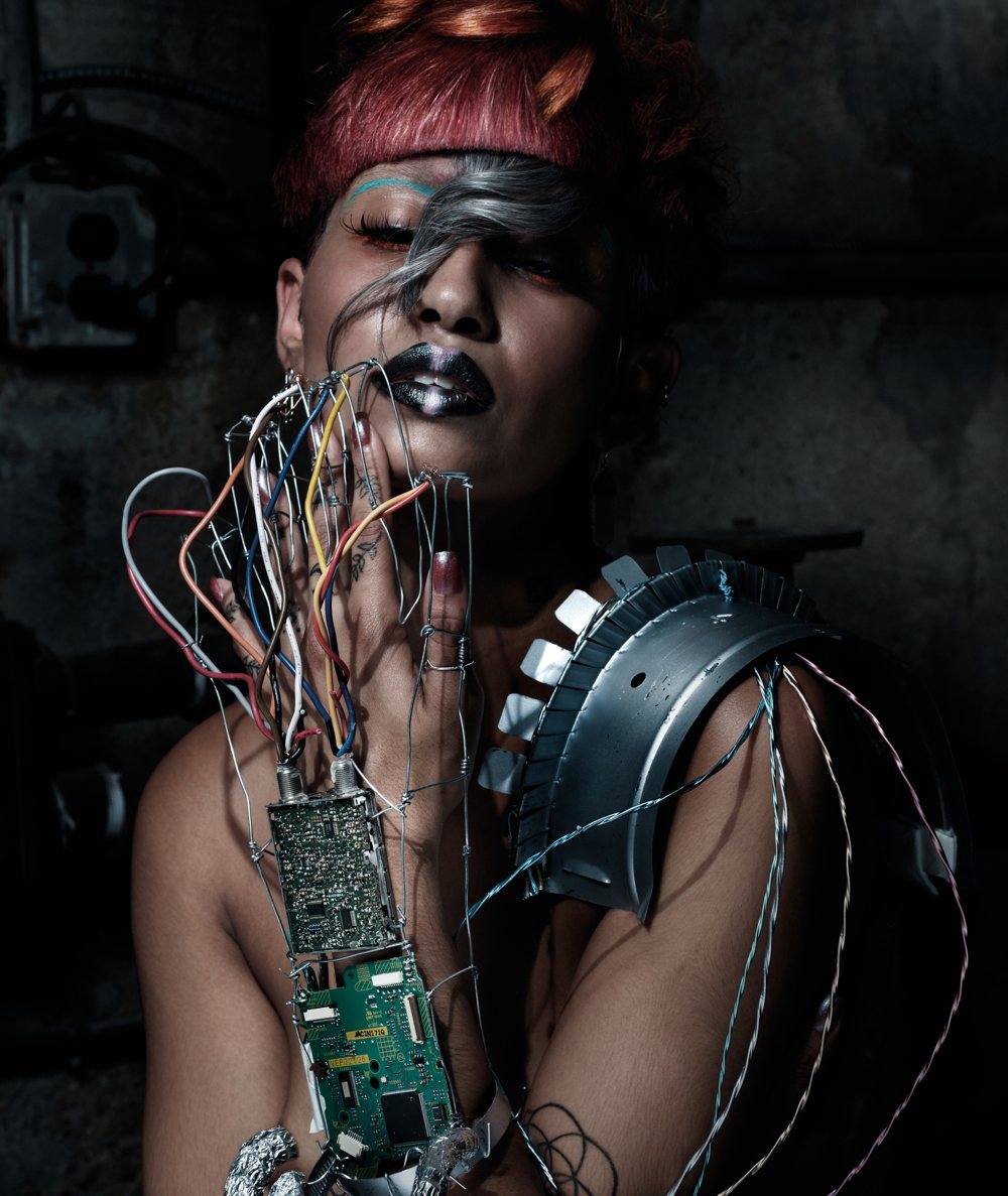 A model with circuit boards and wires over her hand and shoulder